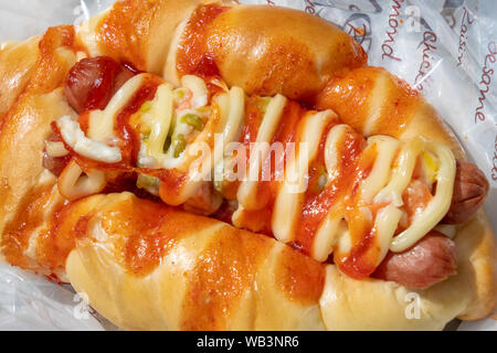 Gebackene Hot Dog mit Salami und Sauce serviert. Stockfoto