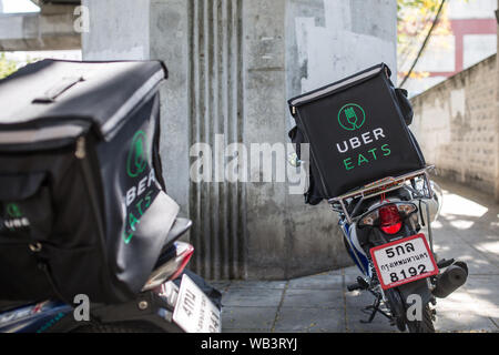 BANGKOK, THAILAND - 27. Januar 2017: Ein Uber isst zwei Motorroller auf der Seite der Straße geparkt. Stockfoto