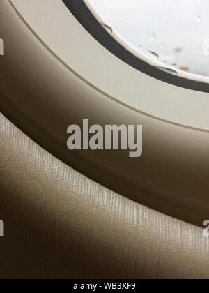 Vertikale Aufnahme des Fensters eines Flugzeugs Stockfoto