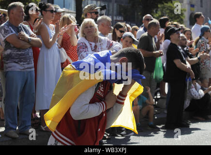 Kiew, Ukraine. 24 Aug, 2019. Ein Mann reagiert, als er steht auf Knie und seine Achtung für Ukrainan Soldaten, der in einen militärischen Konflikt in der östlichen Ukraine teilgenommen, während 'March der Verteidiger der Ukraine "anlässlich der Tag der Unabhängigkeit auf dem Platz der Unabhängigkeit in Kiew, Ukraine, 24. August 2019. Die ukrainer Mark zum 28. Jahrestag der Unabhängigkeit der Ukraine von der Sowjetunion seit 1991. Credit: Serg Glovny/ZUMA Draht/Alamy leben Nachrichten Stockfoto