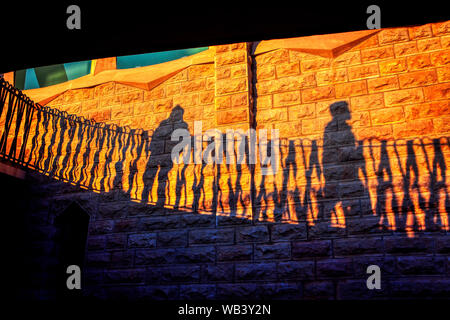 Schattierungen von Passanten an der Wand Stockfoto