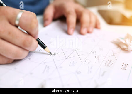 Bild von Mann mit Kalender und Kennzeichnung auf Datum. Auf weissem Hintergrund. Stockfoto