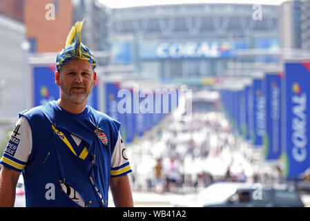 London, Großbritannien. 24 August, 2019. Wembley Stadion, London, England; Rugby Football League Coral das Endspiel um den Challenge Cup, Warrington Wolves gegen St Helens; ein Warrington Wolves Fan steht außerhalb Wembley Park Station mit Wembley Stadion glitzert in der Sonne - redaktionelle Verwendung. Credit: Aktion Plus Sport Bilder/Alamy Live News Credit: Aktion Plus Sport Bilder/Alamy Live News Credit: Aktion Plus Sport Bilder/Alamy Live News Credit: Aktion Plus Sport Bilder/Alamy leben Nachrichten Stockfoto