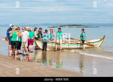 North Berwick, Schottland, Großbritannien, 24. August 2019. Farbenfrohe Ruderskiffe, die an der Regatta aus 12 Ruderclubs in ganz Schottland teilnehmen, treten an einem sonnigen Tag an und rudern 2.5 km um Craigleith Island herum. Der St. Ayles-Skiff ist ein traditionelles Ruderboot mit 4 Ruderbooten. Das Rowporty Ruderclub Boot und Team Stockfoto