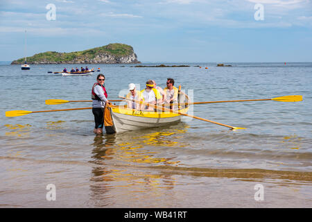 North Berwick, Schottland, Großbritannien, 24. August 2019. Farbenfrohe Ruderskiffe, die an der Regatta aus 12 Ruderclubs in ganz Schottland teilnehmen, treten an einem sonnigen Tag an und rudern 2.5 km um Craigleith Island herum. Der St. Ayle's Skiff ist ein traditionelles Ruderboot mit 4 Ruderbooten. Das Eastern ACRC Coastal Ruderclub Boot & Team Stockfoto