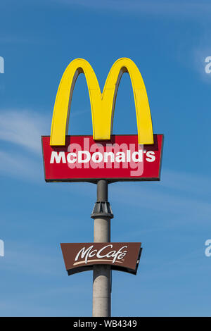 Stade, Deutschland - 22. August 2019: Logos von Mcdonald's und McCafé auf einer Stange gegen den blauen Himmel. Stockfoto