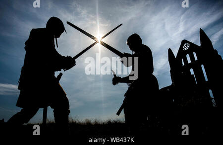 Viking reenactors Battle neben Whitby Abbey, wie Horden von Vikings steigen auf die verschlafene Yorkshire Küstenstadt. Stockfoto