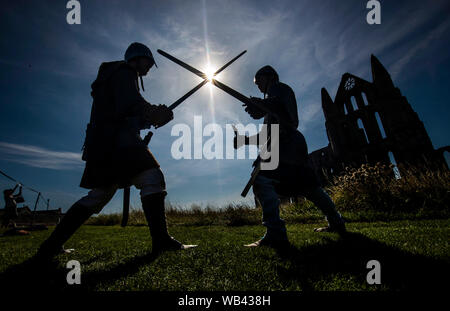 Viking reenactors Battle neben Whitby Abbey, wie Horden von Vikings steigen auf die verschlafene Yorkshire Küstenstadt. Stockfoto