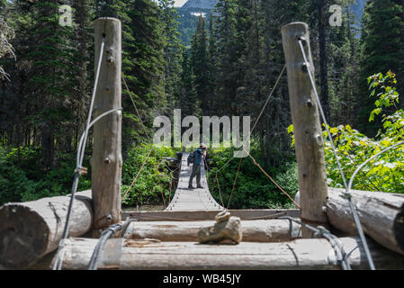 Man steht auf Suspension Bridge und nimmt Foto Stockfoto