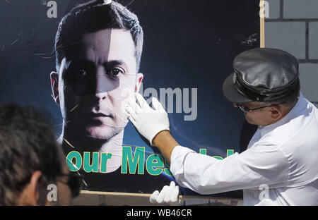 Kiew, Ukraine. 24 Aug, 2019. Ein Mann berührt zu einem Plakat mit Porträt der Ukrainische Präsident Wladimir ZELENSKY und Lesen' Sie sind unser Messias!', während der Feierlichkeiten anlässlich des Tag der Unabhängigkeit auf dem Platz der Unabhängigkeit in Kiew, Ukraine, 24. August 2019. Die ukrainer Mark zum 28. Jahrestag der Unabhängigkeit der Ukraine von der Sowjetunion seit 1991. Credit: Serg Glovny/ZUMA Draht/Alamy leben Nachrichten Stockfoto