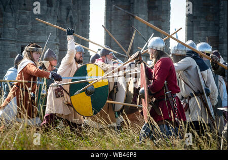 Viking reenactors Schlacht bei Whitby Abbey, wie Horden von Vikings steigen auf die verschlafene Yorkshire Küstenstadt. Stockfoto