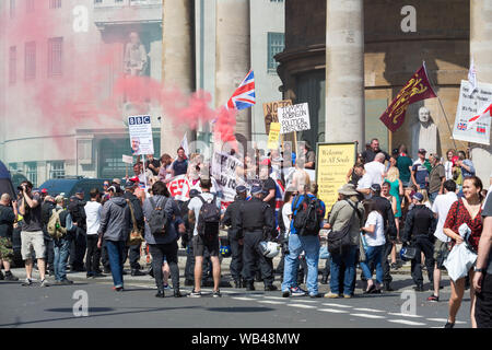 Portland Place, London, Großbritannien. August 2019. Demonstranten treffen sich vor der All Souls Church in der Nähe des BBC Broadcasting House im Zentrum von London. Sichtbare Zeichen sind Anti-Sharia-Slogans, Union Jack-Flaggen, rote Rauchfackeln und Banner, die auf die freie Meinungsäußerung hinweisen. Die Szene ist energiegeladen und konfrontativ, mit einer Mischung aus Demonstranten und Beobachtern. Der kostenlose Tommy Robinson Protest vor der BBC. Gleichzeitig findet eine Gegendemonstration statt, organisiert von Stand up to Rassismus and Unite Against Faschismus. Penelope Barritt/Alamy Live News Stockfoto