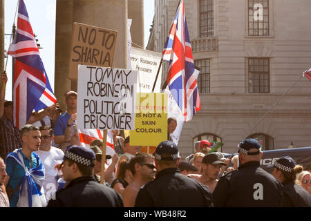 Portland Place, London, Großbritannien. August 2019. Ein politisch aufgeladener Protest im Zentrum Londons mit Plakaten zur Unterstützung von Tommy Robinson, Anti-Sharia-Botschaften und Slogans über Patriotismus und Rasse. Die Flaggen der Union Jack und die Polizeibeamten sind sichtbar, was die Spannungen rund um Nationalismus und Meinungsfreiheit im Vereinigten Königreich deutlich macht. Der kostenlose Tommy Robinson Protest vor der BBC. Gleichzeitig findet eine Gegendemonstration statt, organisiert von Stand up to Rassismus and Unite Against Faschismus. Penelope Barritt/Alamy Live News Stockfoto