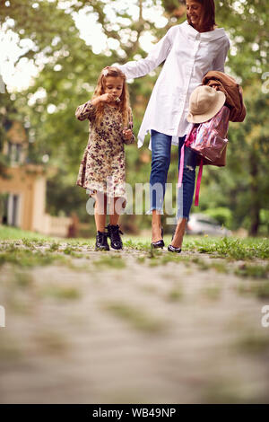 Mutter und niedliche Mädchen von der Schule nach Hause gehen Stockfoto