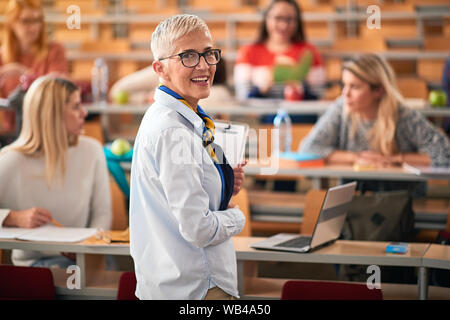 Vortrag an der Universität. Weibliche Lautsprecher geben Präsentation im Hörsaal. Stockfoto