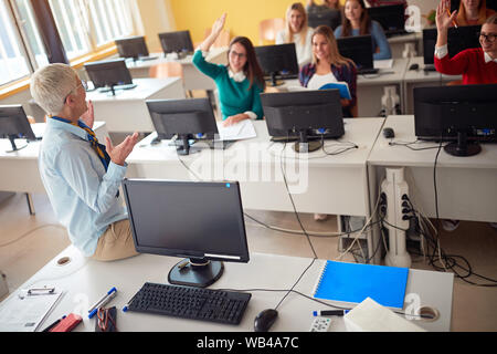 Professor während Vortrag auf dem Campus der Universität am Computer mit Studenten Stockfoto