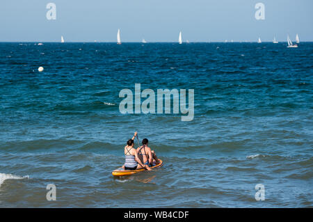 Lübeck-Travemünde, Deutschland. 24. August 2019, Schleswig-Holstein, Lübeck-Travemünde: Zwei Frauen Paddel auf der Ostsee auf Stand-up paddling Board. Foto: Daniel Bockwoldt/dpa Quelle: dpa Picture alliance/Alamy leben Nachrichten Stockfoto