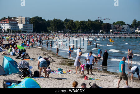 Lübeck-Travemünde, Deutschland. 24. August 2019, Schleswig-Holstein, Lübeck-Travemünde: Viele Menschen in der Ostsee schwimmen. Foto: Daniel Bockwoldt/dpa Quelle: dpa Picture alliance/Alamy leben Nachrichten Stockfoto