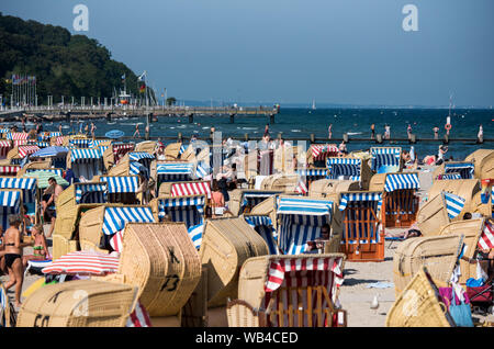 Lübeck-Travemünde, Deutschland. 24. August 2019, Schleswig-Holstein, Lübeck-Travemünde: Zahlreiche Menschen genießen das gute Wetter in Liegen am Strand der Ostsee. Foto: Daniel Bockwoldt/dpa Quelle: dpa Picture alliance/Alamy leben Nachrichten Stockfoto