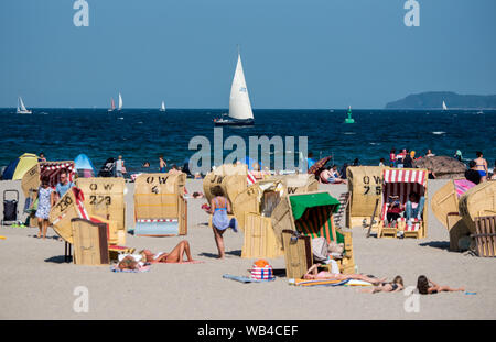 Lübeck-Travemünde, Deutschland. 24. August 2019, Schleswig-Holstein, Lübeck-Travemünde: Zahlreiche Menschen genießen das gute Wetter in Liegen am Strand der Ostsee. Foto: Daniel Bockwoldt/dpa Quelle: dpa Picture alliance/Alamy leben Nachrichten Stockfoto