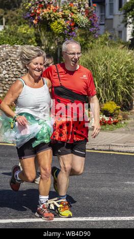 Sidmouth, 24 Aug 19 Läufer auf den Dreibeinigen Rennen in Bank Holiday Sonnenschein in Honiton, Devon. Credit: Foto Central/Alamy leben Nachrichten Stockfoto