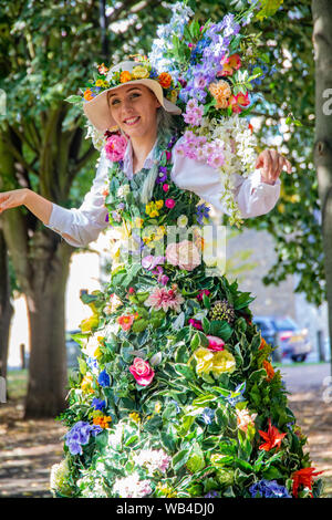 London, Großbritannien. 24 Aug, 2019. Opel Vergnügen Gärten waren zurück in die Zeit der viktorianischen Erfahrung, diese kleine Ecke von South London in einem viktorianischen themed Vergnügungspark verwandelt, mit lebhaften, Spaß, neugierig Zirkusartisten und Musik bringt Viktorianische Vorstellungen von Leben über den ganzen Tag. Zusammen mit Seiltänzer, starke Männer, Music Hall Bands, Stelzenläufer Herr und Frau Flora ganz in duftenden Seidenblumen kostümiert sind. Paul Quezada-Neiman/Alamy Live News Credit: Paul Quezada-Neiman/Alamy leben Nachrichten Stockfoto