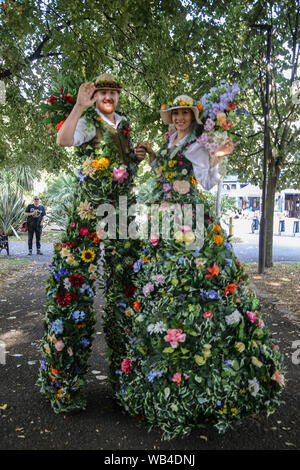 London, Großbritannien. 24 Aug, 2019. Opel Vergnügen Gärten waren zurück in die Zeit der viktorianischen Erfahrung, diese kleine Ecke von South London in einem viktorianischen themed Vergnügungspark verwandelt, mit lebhaften, Spaß, neugierig Zirkusartisten und Musik bringt Viktorianische Vorstellungen von Leben über den ganzen Tag. Zusammen mit Seiltänzer, starke Männer, Music Hall Bands, Stelzenläufer Herr und Frau Flora ganz in duftenden Seidenblumen kostümiert sind. Paul Quezada-Neiman/Alamy Live News Credit: Paul Quezada-Neiman/Alamy leben Nachrichten Stockfoto