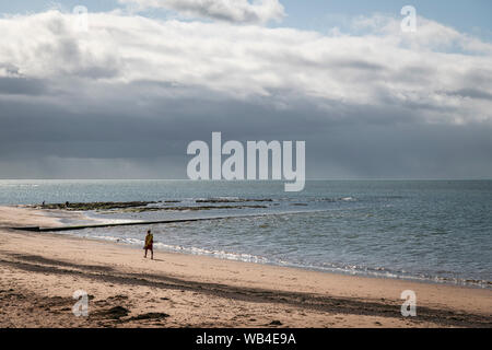 Ein Sommermorgen Spaziergang in der Sonne für ein rnli Rettungsschwimmer am Strand, Exmouth Exmouth, Devon, England. 14. August 2019 Stockfoto