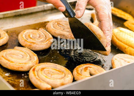 Spirale Würstchen sind in Butter gebraten auf ein Backblech in einem Straßencafe in der Nähe bis Stockfoto