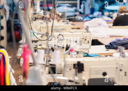 Teilweise verschwommen Innenraum von einem Workshop in einer Textilfabrik mit industriellen Nähtechnik Stockfoto