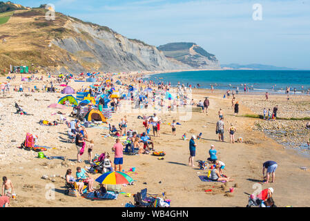 Charmouth, Dorset, Großbritannien. 24 Aug, 2019. UK Wetter: Der Küstenort Charmouth (Lyme Regis' ruhigeren Nachbarn) war besetzt, als Sonnenanbeter am Strand strömten bis die heiße Sonne über die August Bank Holiday Wochenende zu genießen. Credit: Celia McMahon/Alamy leben Nachrichten Stockfoto