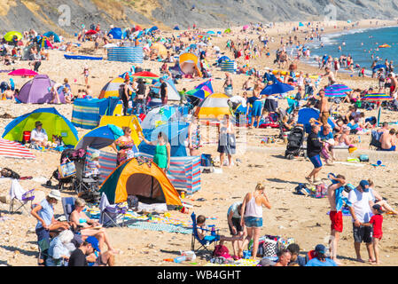 Charmouth, Dorset, Großbritannien. 24 Aug, 2019. UK Wetter: Der Küstenort Charmouth (Lyme Regis' ruhigeren Nachbarn) war besetzt, als Sonnenanbeter am Strand strömten bis die heiße Sonne über die August Bank Holiday Wochenende zu genießen. Credit: Celia McMahon/Alamy leben Nachrichten Stockfoto