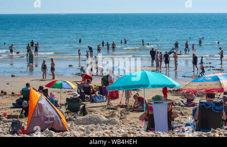 Charmouth, Dorset, Großbritannien. 24 Aug, 2019. UK Wetter: Der Küstenort Charmouth (Lyme Regis' ruhigeren Nachbarn) besetzt war als asunseekers zum Strand strömten bis die heiße Sonne über die August Bank Holiday Wochenende zu genießen. Credit: Celia McMahon/Alamy leben Nachrichten Stockfoto