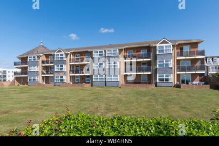 Moderne 3-stöckige Wohnungen am Meer (Apartmentblock) mit Blick auf die Grünanlage am Broadmark Beach, Rustington, West Sussex, England, Großbritannien. Stockfoto