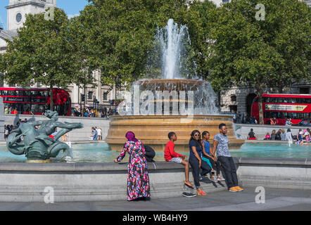 Brunnen und Touristen auf dem Trafalgar Square, Charing Cross, Westminster, London, England, UK. Stockfoto