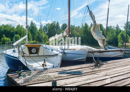 Kleine Segelboote günstig an einer hölzernen Pier Stockfoto