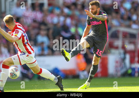 Stoke-on-Trent, Großbritannien. 24 Aug, 2019. Leeds United defender Stuart Dallas (15) schießt auf der Stoke City Ziel während der efl Sky Bet Championship Match zwischen Stoke City und Leeds United in der Bet365-Stadion, Stoke-on-Trent, England am 24. August 2019. Foto von Jurek Biegus. Nur die redaktionelle Nutzung, eine Lizenz für die gewerbliche Nutzung erforderlich. Keine Verwendung in Wetten, Spiele oder einer einzelnen Verein/Liga/player Publikationen. Credit: UK Sport Pics Ltd/Alamy leben Nachrichten Stockfoto