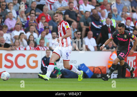 Stoke-on-Trent, Großbritannien. 24 Aug, 2019. Stoke City defender Liam Lindsay (5) jagt den Ball mit Leeds United Mittelfeldspieler Jack Harrison (22) in der Nähe hinter ihm während der efl Sky Bet Championship Match zwischen Stoke City und Leeds United in der Bet365-Stadion, Stoke-on-Trent, England am 24. August 2019. Foto von Jurek Biegus. Nur die redaktionelle Nutzung, eine Lizenz für die gewerbliche Nutzung erforderlich. Keine Verwendung in Wetten, Spiele oder einer einzelnen Verein/Liga/player Publikationen. Credit: UK Sport Pics Ltd/Alamy leben Nachrichten Stockfoto