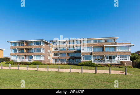 Moderne Wohnungen am Meer (Appartementblock) mit 3 und 4 Etagen mit Blick auf die Grünanlage in Rustington. West Sussex, England, Großbritannien. Stockfoto