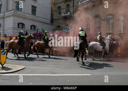 Polizisten auf Pferden umgeben die anti Faschismus Demonstranten während der Rallye. Anhänger außerhalb BBC versammelt, die Freiheit ihrer gefangengesetzt Rechten Führer Stephen Yaxley-Lennon aka Tommy Robinson zu verlangen. Während der Rallye, die Polizei eingreifen musste und ihre Schlagstöcke heben, wenn ein Polizeiwagen durch die Tommy Robinson Anhänger angegriffen wurde. Eine Person wurde nach der Konfrontation verhaftet. Stockfoto