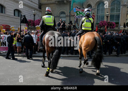 Polizisten auf Pferden umgeben die anti Faschismus Demonstranten während der Rallye. Anhänger außerhalb BBC versammelt, die Freiheit ihrer gefangengesetzt Rechten Führer Stephen Yaxley-Lennon aka Tommy Robinson zu verlangen. Während der Rallye, die Polizei eingreifen musste und ihre Schlagstöcke heben, wenn ein Polizeiwagen durch die Tommy Robinson Anhänger angegriffen wurde. Eine Person wurde nach der Konfrontation verhaftet. Stockfoto