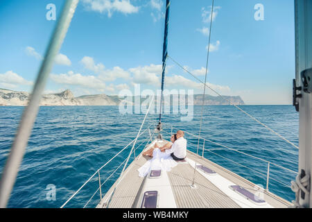 Junges Paar Entspannen auf einer Yacht. Happy wohlhabender Mann und eine Frau, die mit dem eigenen Boot haben Meer Reise Stockfoto