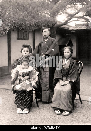 [1920s Japan - japanische Familie, die in förmlichen] - japanische Familie im Kimono posiert vor Verschleiß. 20. Jahrhundert vintage Silbergelatineabzug. Stockfoto