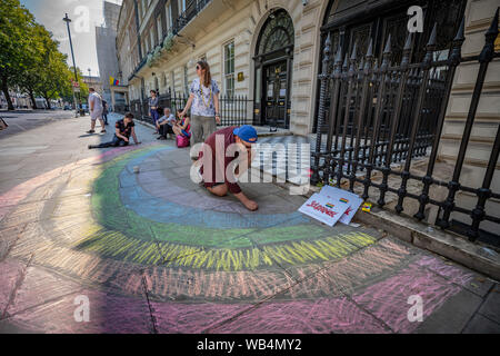 London, Großbritannien. 24 August, 2019. Solidarität mit LGTBQ + Gemeinschaft in Polen friedlichen Protest vor der polnischen Botschaft in London. LGTBQ + Mitglieder und Unterstützer ein Chalk Regenbogen von Solidarität außerhalb der Botschaft, bevor Sie reden mit Informationen über das aktuelle anti-homosexuellen Klima in Polen. Politiker der Regierungspartei Recht und Gerechtigkeit zusammen mit Beamten der immer noch einflussreiche katholische Kirche werfen der LGBTQ + Gemeinschaft als Bedrohung für Kinder und nach Polen. Credit: Guy Corbishley/Alamy leben Nachrichten Stockfoto