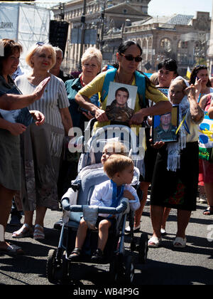 Die Witwe eines ukrainischen Krieger mit Zwillingen in einem Kinderwagen nimmt teil, die in der März. Der März der Verteidiger auf der 28. Jahrestag der Unabhängigkeit der Ukraine in Kiew. Über 12 tausend Menschen nahmen daran teil: Veteranen, Freiwilligen und Angehörigen der in den Krieg gegen die russische Aggressor in der östlichen Ukraine getötet. Darüber hinaus mehr als 55.000 Menschen in der Feier der Tag der Unabhängigkeit in der Hauptstadt der Ukraine teilgenommen. Stockfoto