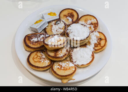 Mini niederländischen Pfannkuchen, Poffertjes, auf einer weißen Platte, in einem Café in Amsterdam, Niederlande Stockfoto