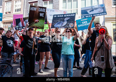 Eine Gruppe von Tierschuetzer skandieren Parolen und Plakate vor einer Metzgerei während der Demonstration. Dies ist das zweite Mal, dass die Rechte der Tiere März in den Niederlanden stattgefunden hat. Tausende Tierfreunde in Amsterdam versammelt, oben zu stehen und sprechen sich gegen alle Formen, in denen Tiere verwendet werden, missbraucht und ausgebeutet. Stockfoto