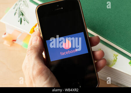 Hand, die ein Smartphone mit einer Facebook Zunder dating Symbol auf dem Bildschirm. IPhone mit einem social media app Logo. Amsterdam 2019.03.20 Stockfoto