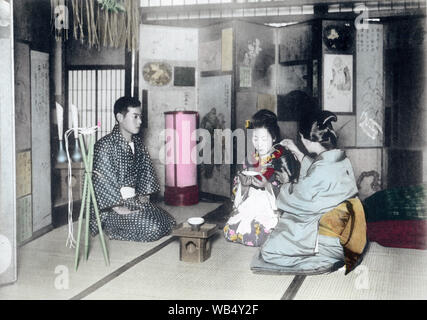 [1900s Japan - japanische Hochzeit] - Japanische Ehe: die Mutter des Bräutigams bietet die neu verheirateten Paar willen während einer arrangierten Ehe (omiai). Dieses Bild stammt aus "Die Zeremonien eines japanischen Ehe", 1905 veröffentlicht (Meiji 38) von Kobe Fotograf Teijiro Takagi. Original Text: "Die gesamte Zeremonie endet, durch die Mutter ihren Sohn und die neu erworbene Tochter geben, eine Final Cup Der ake, "mit ihrem Segen. 20. Jahrhundert vintage Lichtdruck drucken. Stockfoto