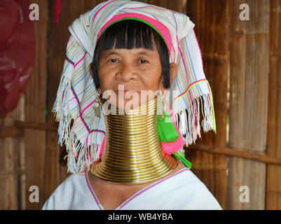 Ältere Karen lange Hals Verkäuferin - gedreht - Modell mit polierten traditionellen Messing Hals Spulen posiert für die Kamera. Stockfoto